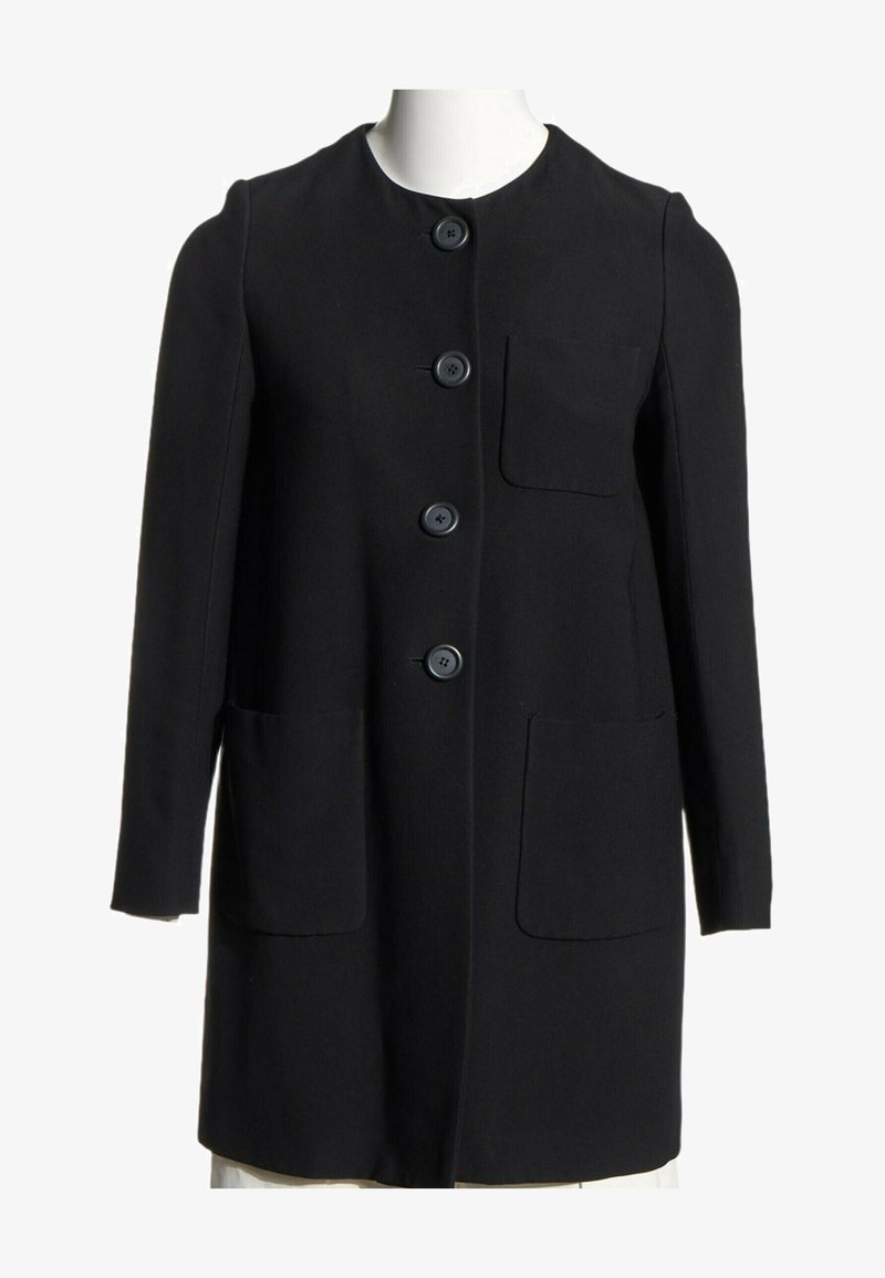 Manteau noir à manches longues avec col rond, quatre boutons devant et trois grandes poches devant, présenté sur un mannequin blanc.
