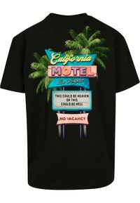 Tricou negru cu un grafic colorat al unui semn de motel din California, cu palmieri, care afișează text și elemente de design vibrante.