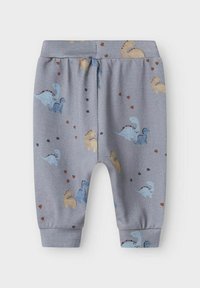 Graue Baumwoll-Jogginghose mit bunten Dinosauriermustern und kleinen Herzakzenten. Elastischer Bund und Rippbündchen. Weicher Stoff.