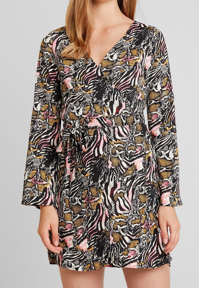 Czarna sukienka z dekoltem w kształcie litery V, długimi rękawami i paskiem w talii, z wyrazistym nadrukiem zwierzęcym w połączeniu z różowymi, żółtymi i białymi akcentami.