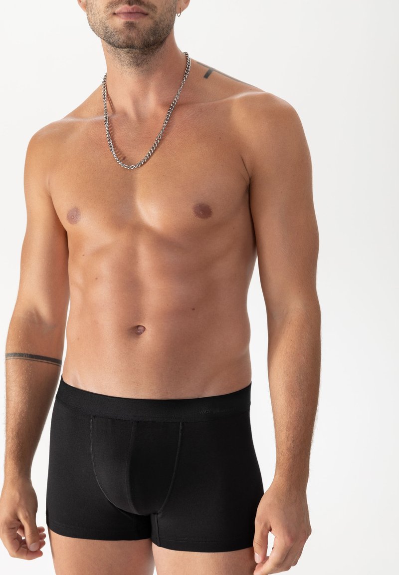 Schwarze Baumwoll-Boxershorts mit figurbetonter Passform und elastischem Bund, mit einem dezenten Nahtdetail und minimalistischem Design.