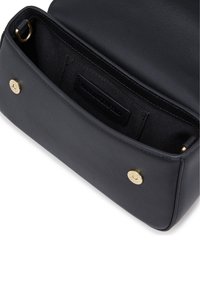 Interno di una borsa a tracolla nera in pelle, caratterizzato da una texture liscia, accessori in oro e un'etichetta. Chiusura magnetica senza caratteristiche esterne visibili.
