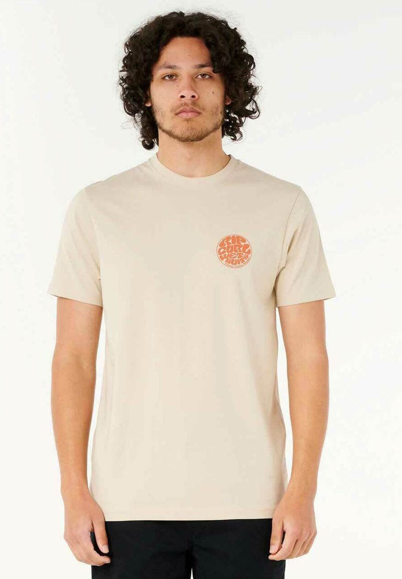 Beige bomulds t-shirt med korte ærmer, rund hals og et cirkulært orange grafik på venstre bryst. Glat tekstur, afslappet pasform.