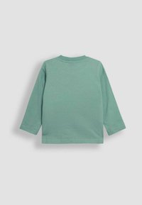 Lange mouw, mintgroen shirt gemaakt van zachte katoen. Heeft een ronde halslijn en eenvoudige stiksels langs de randen. Geen graphics of patronen.