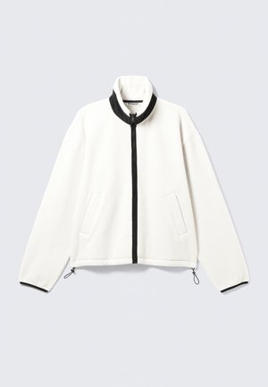 Giacca in fleece bianca con zip nera frontale, colletto alto, due tasche laterali e polsini elasticizzati con lacci regolabili all'orlo.