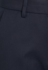 Granatowe spodnie z tkaniny o splocie, charakteryzujące się eleganckim designem, gładką fakturą oraz starannie obszytym pasem z przednim zapięciem.