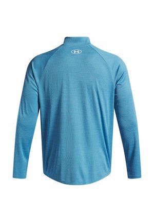 Long-sleeve, light blue athletic shirt with a high collar. Made from textured fabric, featuring a logo on the back near the neckline.