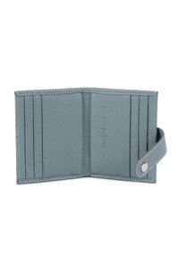 Portefeuille en cuir bleu clair avec une finition texturée, comportant cinq emplacements pour cartes, une fermeture à pression et des coutures contrastées.
