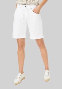 Witte katoenen shorts met een trekkoord in de taille, voorzakken en een ontspannen pasvorm. Gecombineerd met lichtgekleurde veterschoenen.