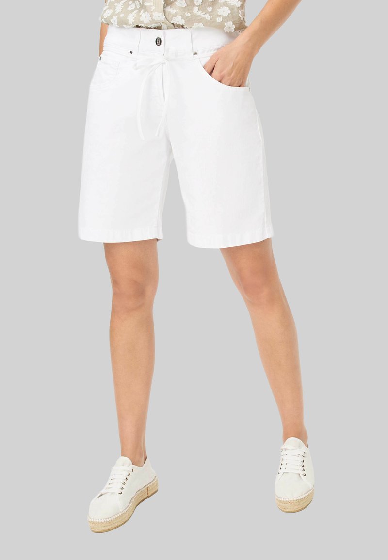 Witte katoenen shorts met een trekkoord in de taille, voorzakken en een ontspannen pasvorm. Gecombineerd met lichtgekleurde veterschoenen.