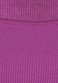 Ribbat tyg i livlig magenta med en något fransig kant. Slät textur överlag, med vertikala linjer över ytan.