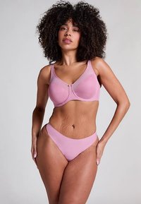Svijetloroze grudnjak i odgovarajuće gaćice s visokim strukom od glatkog materijala. Grudnjak ima žice i zatvaranje sprijeda s suptilnim dizajnom.