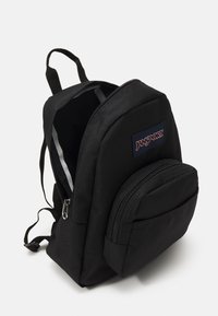 Crni platneni ruksak s glavnim odjeljkom i prednjim zip džepom. Ima podesive naramenice i oznaku Jansport. Teksturirana površina.