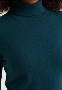 Pull encolure zippée en tricot teal, fabriqué à partir d'un tissu doux, avec un design ajusté et des bords côtelés. Texture lisse, sans motifs ou accents visibles.