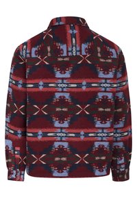 Chemise en flanelle rouge et marine avec un motif géométrique complexe, des poignets boutonnés et un col pointu. Le tissu a une texture douce.