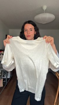 Bílé lehké bavlněné tričko s kulatým výstřihem a krátkými rukávy, s mírnou texturou a volným střihem.