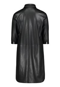 Cappotto in pelle nera con maniche corte, colletto e una silhouette leggermente svasata. Presenta una texture liscia e bordi grezzi.