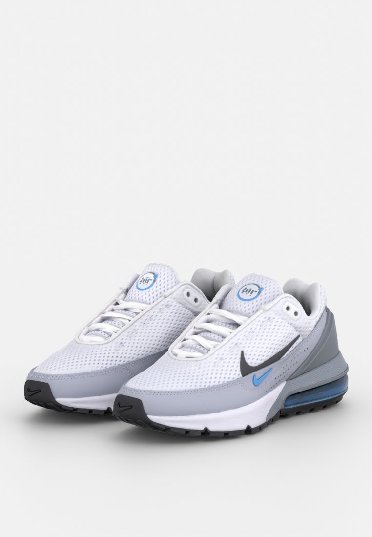 Baskets Nike avec une tige en mesh blanche, des accents gris, un logo bleu et une semelle rembourrée dotée d'une unité d'air visible. Lacets plats et semelle en caoutchouc.