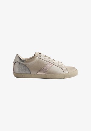 Beżowe skórzane sneakersy niskie, z metalicznymi akcentami w kolorze srebrnym i różowego złota, okrągłym czubkiem oraz teksturowanymi bokami, na gumowej podeszwie.