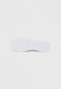 Λευκή σόλα αθλητικού παπουτσιού με υφασμένο καουτσούκ στο κάτω μέρος, με σχέδιο ψαροκόκαλου και στρογγυλεμένες άκρες, τονισμένη με ροζ λεπτομέρεια λογότυπου.