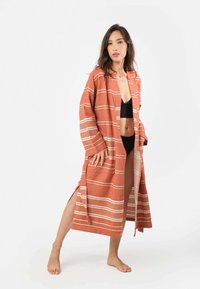 Hlinený dlhý kimono v terrakotovom odtieni s bielymi prúžkami, s otvoreným predným dielom, širokými rukávmi a bočnými rozparkami; vyrobené z ľahkého materiálu.