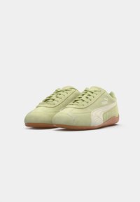Sneakers din suede verde deschis cu accente albe, vârf rotunjit, sistem de închidere cu șireturi și talpa din cauciuc natural. Prezintă logo-ul Puma pe lateral.