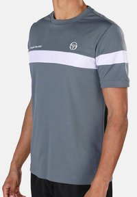 Grijze sport t-shirt met witte horizontale strepen, korte mouwen, ronde hals, gemaakt van lichtgewicht stof, met een logo op de linkerborst.