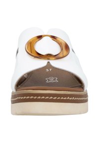 White leather sandal with open design, featuring a large brown circular accent and a textured tan sole. Size 37 indicated.