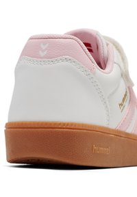 Hvid syntetisk sneaker med pink detaljer, tekstureret tan gummisål, velcrolukning og guldbranding. Har syningsdetaljer.