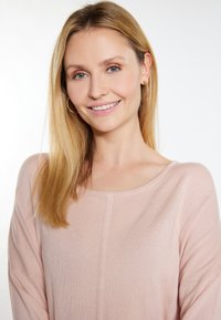 Top roz deschis, lejer, cu decolteu rotunjit, textură moale și umeri lăsați, completat de detalii subtile de cusătură.