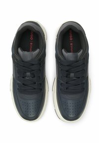 Granatowe skórzane trampki z perforowanym noskiem, wyściełanymi szarymi akcentami, sznurowanym zapięciem i kremową gumową podeszwą. Czerwone logo na wkładce.