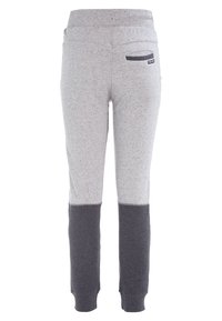 Pantalones de chándal en dos tonos de gris con sección superior clara y sección inferior oscura, cinturilla elástica, bolsillo trasero con ribete oscuro y tobillos acampanados.