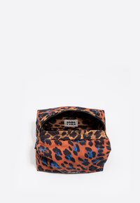 Neceser de estampado de leopardo con forma redondeada, hecho de tela que presenta tonos cálidos de marrón, negro y azul, desabrochado para mostrar su interior.