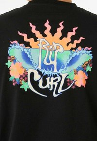 Zwarte t-shirt met een kleurrijk bedrukt ontwerp met golven, zonnestralen en bloemachtige elementen in roze, groen, blauw en oranje tinten.