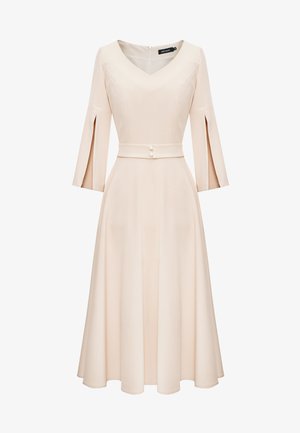 Jasno brzoskwiniowa sukienka z dekoltem w serek, rękawami trzy czwarte w kształcie dzwonu, dopasowaną talią z paskiem i guzikami oraz zwiewnym spódnicą do kolan. Gładka faktura.