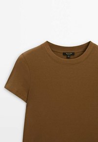Brun, ribbet kortærmet t-shirt med en klassisk rund halsudskæring og et mærke detaljeret på kraven. Blødt, struktureret stof.