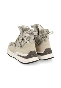Zapatillas deportivas de color beige claro con un acabado suave de ante y una parte superior acolchada de tejido gris brillante. Cuentan con cordones elásticos y una suela de goma gris oscuro.