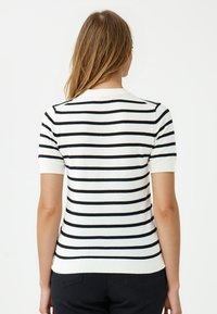 Gestreepte korte mouwen trui in cream en zwart, met horizontale strepen, een ronde hals, geribbelde zoom en een gladde brei-textuur.