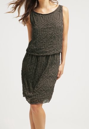 Robe sans manches vert foncé avec un motif texturé de formes géométriques et de perles. Silhouette fluide avec une coupe ample. Tissu doux.