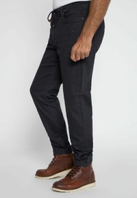 Pantaloni jogger neri con vita elastica e polsini alle caviglie. Realizzati in un tessuto morbido, presentano tasche laterali e dettagli di cucitura a contrasto.