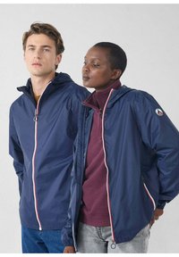 K-way blu navy con cerniere a contrasto, uno indossato sopra una maglia color amaranto, dotati di cappuccio e polsini elasticizzati, mostrati da due modelli.