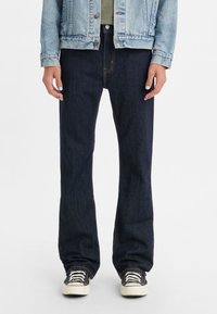Dark blue denim jeans with a straight-leg cut. Features a classic five-pocket design, orange stitching, and a zipper fly.