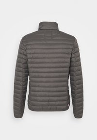 Grijze geïsoleerde jas met een quilted ontwerp, staande kraag en lange mouwen. Bevat een logo-accent op de zoom. Textuurachtig uiterlijk.