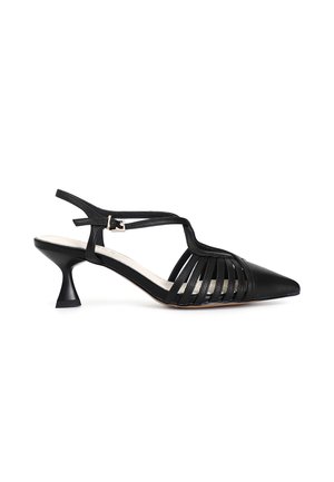 Scarpa slingback in pelle nera con punta affusolata, caratterizzata da cinghie con tagli verticali e un tacco kitten scolpito. Cinturino alla caviglia regolabile.