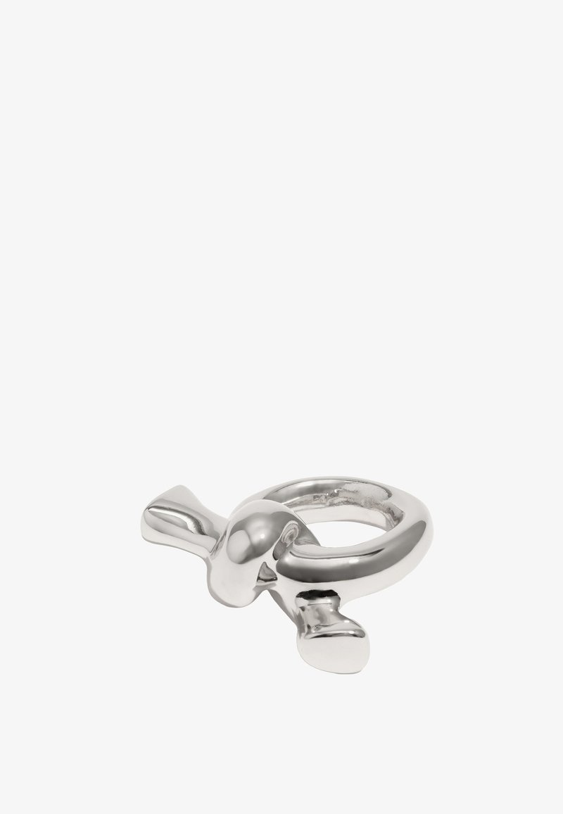 Anillo de metal plateado con una articulación esférica y dos extremos planos y redondeados. Su superficie suave refleja la luz, creando acentos brillantes.