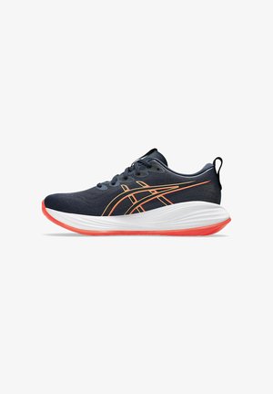 Baskets de sport navy avec des accents orange, dessus en tissu léger, semelle blanche rembourrée, bout arrondi, et une languette au talon pour un enfilage facile.