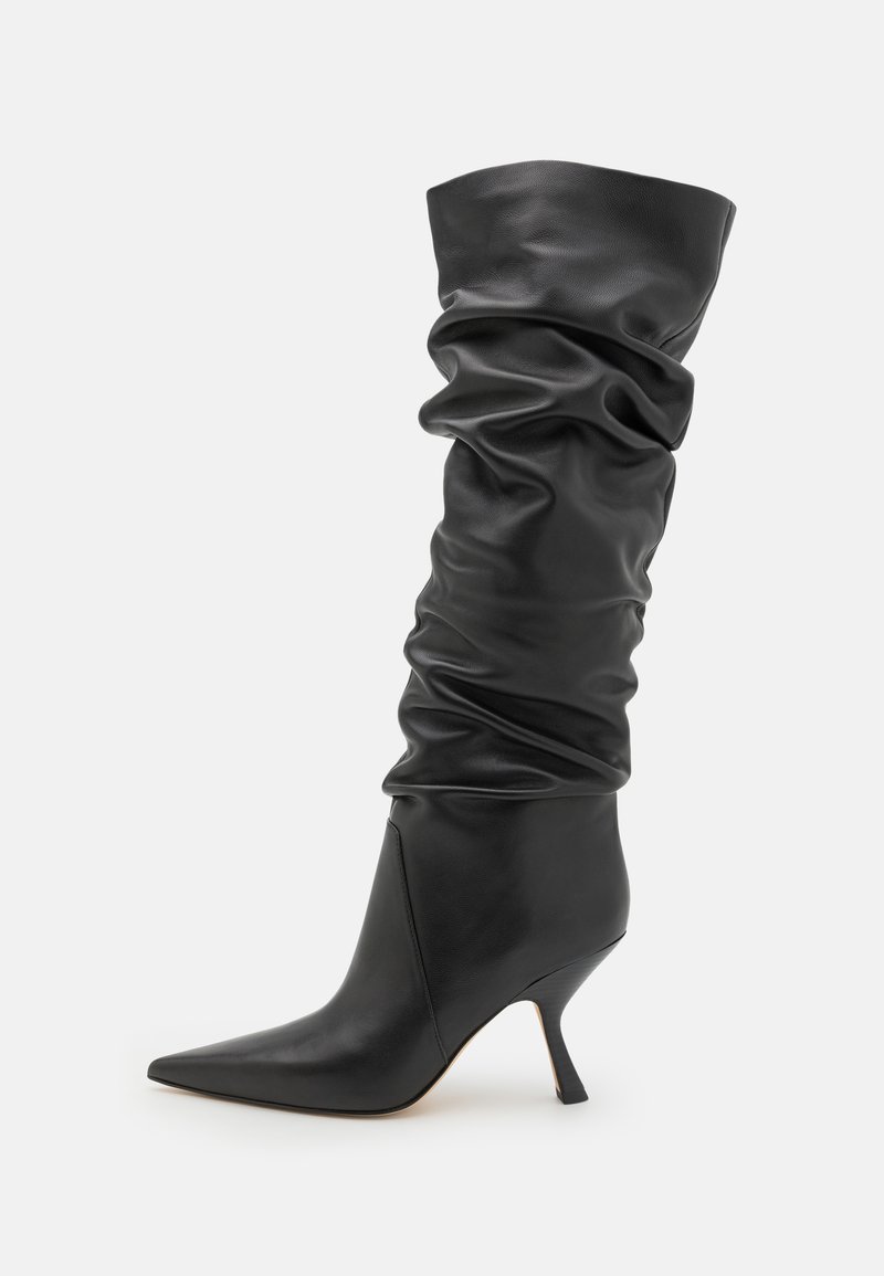 Black leather ankle boot with a slouchy design, pointed toe, and a slender kitten heel. Smooth texture with subtle folds and creases.