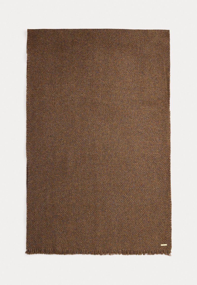 Hnedý tkaný prikrývka s textúrovaným povrchom, s strapcovými okrajmi a jemnými farebnými variáciami, ktoré vytvárajú teplý, útulný vzhľad.