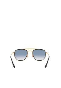 Occhiali da sole ottagonali dorati e neri con lenti azzurrine sfumate. Presentano naselli, punte delle aste nere e un sottile ponte dorato.