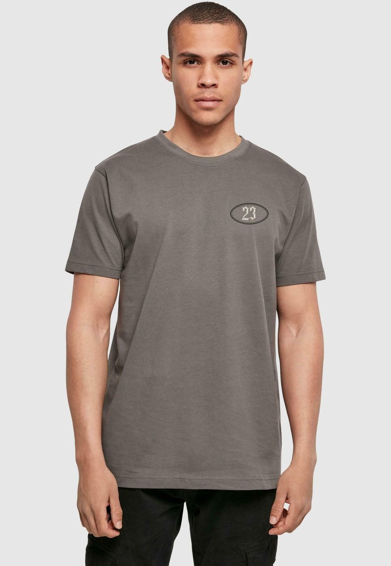 Grå t-shirt med korte ærmer lavet af bomuld, med et lille oval logo på venstre brystområde. Standard afslappet pasform og rund halsdesign.